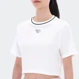 Remera corta blanca de algodón con cuello redondo ribeteado en negro y logo Reebok bordado en el pecho.