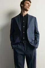Blazer regular fit azul marino confeccionada en tejido con 20% de lana. Cuenta con cuello con solapas de muesca, manga larga con botones en los puños, bolsillos de vivo en el pecho y de solapa en la cadera, y cierre frontal con botones.