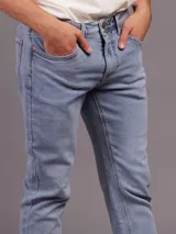 Jean de corte slim fit con cintura media, confeccionado en denim de tono azul claro con acabado lavado.