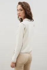 Remera de cuello alto y manga larga en color crudo, con costuras a la vista en contraste de color marrón.