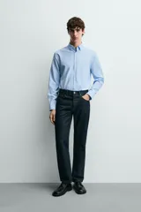 Camisa de corte slim fit, color negro, con cuello italiano, manga larga con puños abotonados y cierre frontal de botones. Confeccionada en tejido de fácil cuidado que minimiza la necesidad de planchado.