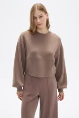 Buzo negro de corte cropped, con cuello redondo y mangas largas abullonadas.