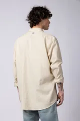 Camisa de manga larga confeccionada en lino, color verde oliva, con cuello clásico y cierre frontal de botones.