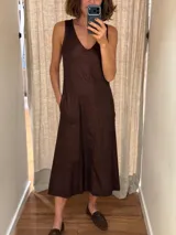 Vestido midi de lino con diseño bicolor dividido en tonos beige y marrón, escote en V, sin mangas y corte holgado con bolsillos laterales.