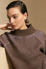 Polera de tejido acanalado en color marrón con detalles de líneas en tono lila, cuello alto y mangas largas con diseño raglán.
