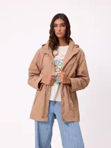 Rompevientos negro con capucha ajustable mediante cordones, cierre frontal de cremallera y ajuste en la cintura con cordón. Presenta logo de la marca bordado en el pecho y puños con detalle de botón.