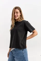 Remera oversize de algodón en color negro con efecto lavado, cuello redondo y mangas cortas.
