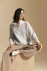 Polera de tejido acanalado en color marrón con detalles de líneas en tono lila, cuello alto y mangas largas con diseño raglán.