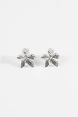 Caravanas metálicas con diseño de flor de cinco pétalos con acabado texturizado, equipadas con sistema de cierre tipo clip.