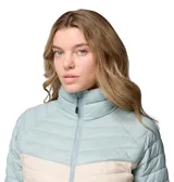 Campera técnica Columbia modelo Powder Pass con tecnología Omni-Shield resistente al agua y aislamiento térmico Thermarator. Presenta un diseño de bloques de color en tonos celeste y beige, con cierre frontal completo, cuello alto con protección para la barbilla y bolsillos laterales con cremallera.