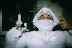 Campera puffer blanca con capucha y logo reflectivo en el pecho.