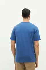 Remera de manga corta color rosado, con estampado frontal de hojas en tonos azules y texto "Organiquis Les Formes" y "Bisfield Est. 1971".