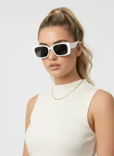 Lentes de sol de montura gruesa y rectangular, color blanco cremoso. Los cristales son oscuros y tienen un diseño moderno y llamativo.