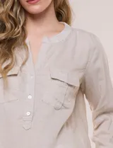 Blusa de lino de la marca Dash, color beige, con cuello mao y escote en V con botones frontales. Cuenta con bolsillos plaqué con solapa en el pecho y mangas largas con sistema para arremangar.
