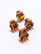 Set de cuatro pinzas para el cabello pequeñas con diseño de carey en tonos marrones y negros, con mecanismo de resorte metálico.