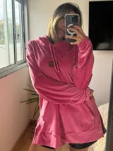 Buzo de plush oversize color fucsia, con capucha y cordones.