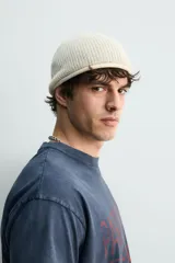 Gorro de punto tejido en hilatura de lino, con diseño clásico y acabado con vuelta en el borde.