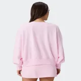 Buzo rosado con hombros caídos, cuello redondo y diseño holgado, confeccionado en suave felpa.