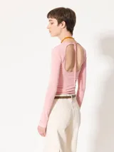 Remera de punto con textura suave, manga larga y escote redondo. Presenta un diseño ajustado al cuerpo con espalda abierta y largo a la primera cadera.