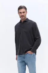 Camisa de pana de algodón con cuello clásico, cierre frontal de botones y mangas largas. Presenta un diseño de corte regular con textura suave y acabado mate.