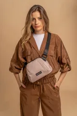 Bandolera pequeña de diseño moderno, confeccionada en tafeta liviana y resistente. Cuenta con cierre superior, correa ancha ajustable y logo frontal de la marca.