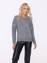 Sweater color beige de tejido de punto con cuello redondo y mangas largas con detalle de costuras blancas en los hombros.