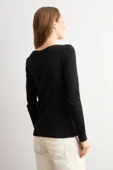 Remera de manga larga en color blanco, con escote bote y corte ajustado al cuerpo.