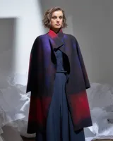 Tapado largo de lana merino afieltrada color rojo y violeta con diseño degradado. Tiene bolsillos laterales y puede usarse suelto o cruzado.