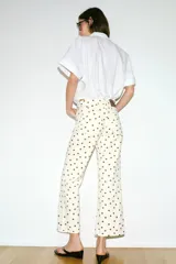 Jeans de tiro medio con diseño de cinco bolsillos, corte mini flare y bajo evasé. Presenta un estampado de lunares en contraste.
