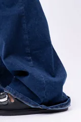 Pantalón de jean estilo oxford, de tiro alto y color azul oscuro, con corte ajustado en la parte superior y acampanado hacia el ruedo.