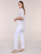 Camisa holgada de algodón liviano con estampa botánica en tonos beige y blanco, cuello camisero y mangas largas.