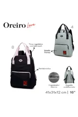 Mochila negra con detalles en rosa claro, incluyendo asas superiores y tirantes ajustables con el logo de la marca. Presenta un bolsillo frontal con cierre y un logo rojo en la parte inferior.