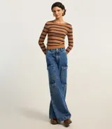 Blusa corta de tejido de punto a rayas horizontales color verde y blanco, de mangas largas y cuello redondo.