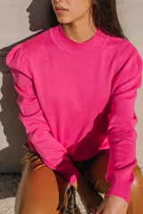 Sweater de hilo color fucsia, con cuello redondo y hombros abullonados.