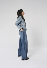 Jean de corte barrel fit con tiro alto y pierna holgada, confeccionado en denim de algodón con lavado azul medio.
