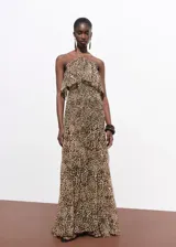 Vestido maxi largo de chifón con estampado animal print de leopardo. Presenta cuello halter con cierre de nudo, escote palabra de honor con gran volante superior y cuerpo elástico fruncido.