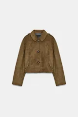 Chaqueta corta de efecto ante en color marrón, con cuello solapa, manga larga y trabillas en los hombros. Presenta cierre frontal con botones y bolsillos delanteros de doble vivo.