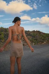 Vestido corto color gris, confeccionado en lino y rayón, con escote recto, breteles regulables y espalda con tiras regulables.