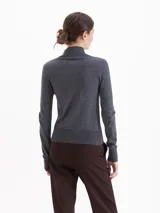 Polera de tejido fino con cuello alto, manga larga y calce entallado al cuerpo.