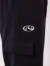 Babucha de estilo cargo en color negro, confeccionada en tejido de algodón y poliéster. Presenta cintura elástica con cordón ajustable, bolsillos laterales tipo cargo y puños elásticos en los tobillos.