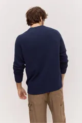 Sweater de punto color azul marino con cuello redondo, mangas largas y detalles acanalados en cuello, puños y ruedo.