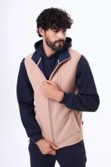Chaleco de micropolar color beige con cierre frontal completo y bolsillo vertical en el pecho.