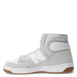 Championes New Balance modelo 480 de caña media, confeccionados en cuero de plena flor con detalles en gamuza. Presentan un diseño inspirado en el básquetbol clásico, con el logo 'N' en los laterales, suela reforzada y plantilla OrthoLite para mayor confort y amortiguación.