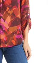 Blusa de gasa con estampado abstracto en tonos marrones, naranjas y fucsias. Presenta cuello mao con escote en V y mangas largas con sistema de ajuste mediante presilla y botón.
