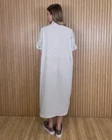 Vestido midi estilo túnica color celeste con rayas verticales blancas, cuello camisero, mangas cortas y cierre frontal con botones ocultos.