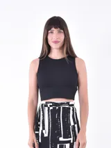 Musculosa corta negra de tejido de punto acanalado, con cuello redondo y sisas amplias.
