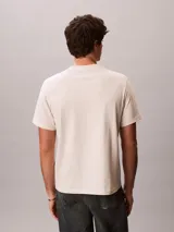 Remera de manga corta Calvin Klein color beige, de corte regular y cuello redondo, con el monograma de la marca estampado en el pecho.