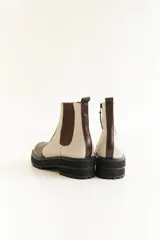 Botas Chelsea de cuero color marrón, con elástico lateral negro y suela track color caramelo.