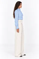 Blusa rosada de 100% lino natural, con cuello alto con volado, mangas largas abullonadas y cierre frontal de botones con detalles de volados en la cartera.