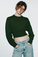 Jersey de punto liso con diseño cropped, cuello redondo y manga larga. Presenta acabados en rib en cuello, puños y bajo.